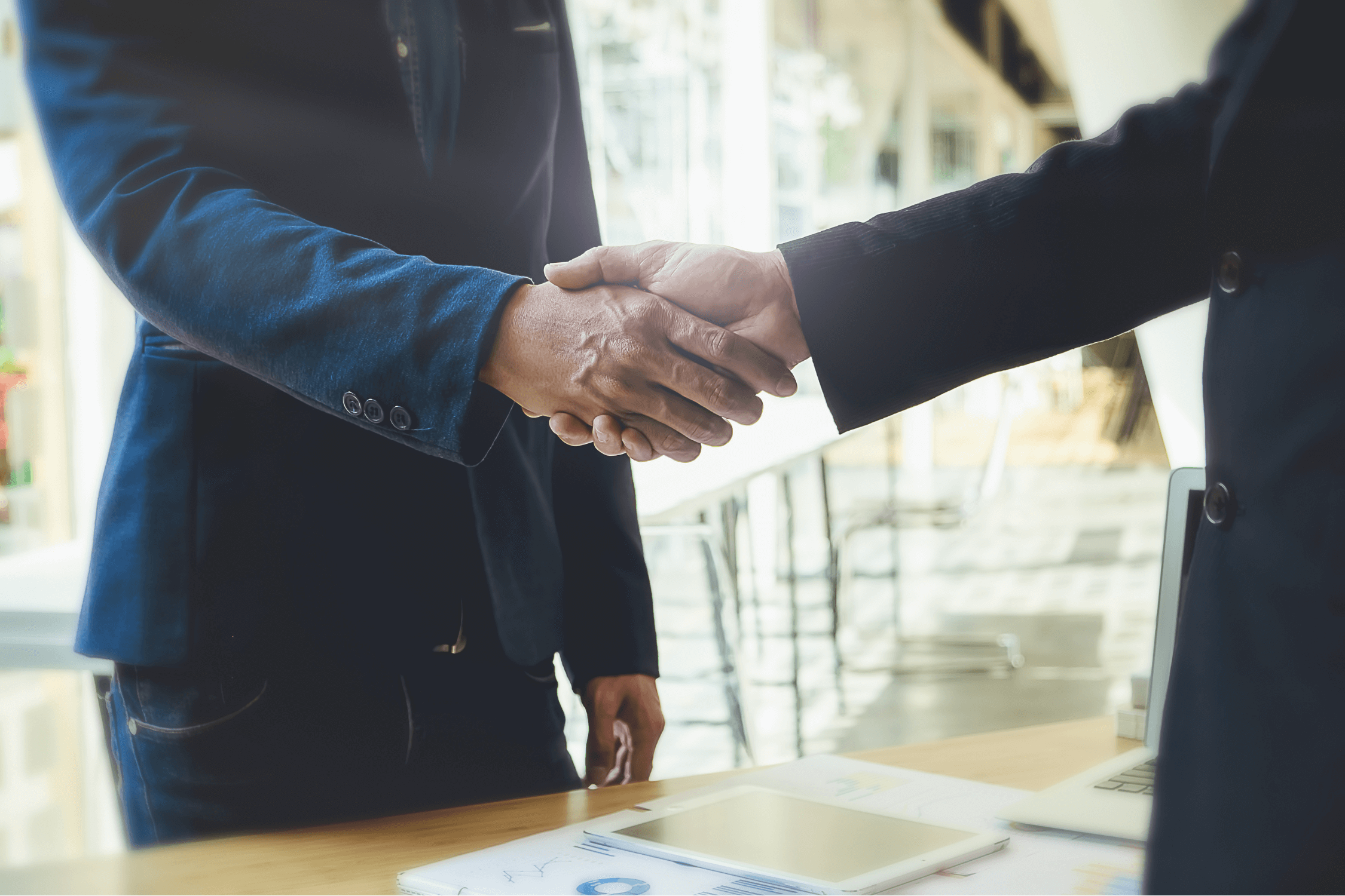 Two men shaking hands as they form a partnership which is a type of unincorporated business