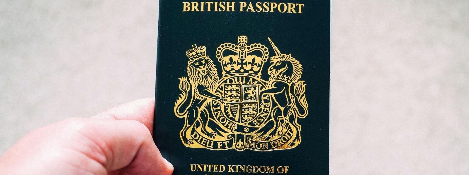 A hand holding a British passport